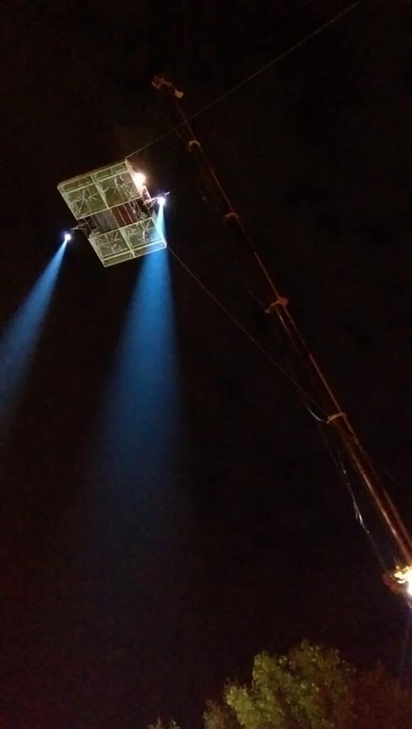 Scheinwerfer bei Dunkelheit in großer Höhe an einer Kran-Plattform auf einem Filmset