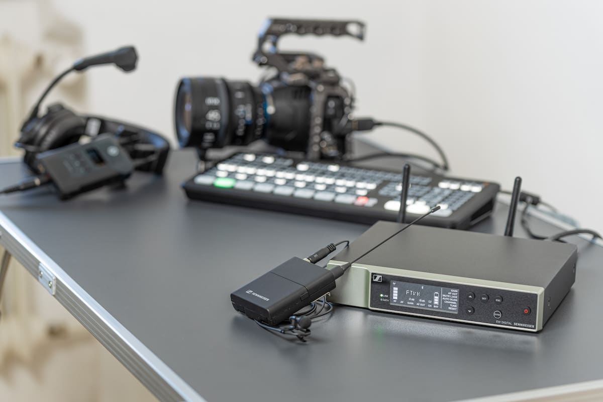 Das Sennheiser Evolution Wireless Digital System liegt auf einem Tisch, im Hintergrund Streaming-Ausrüstung