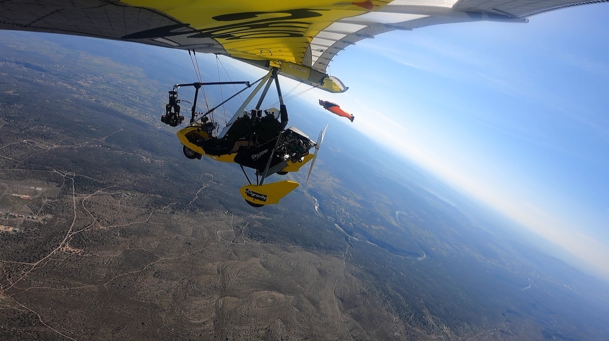 Ein Ultraleichtflugzeug mit Gimbal filmt einen Fallschirmspringer mit Wingsuit